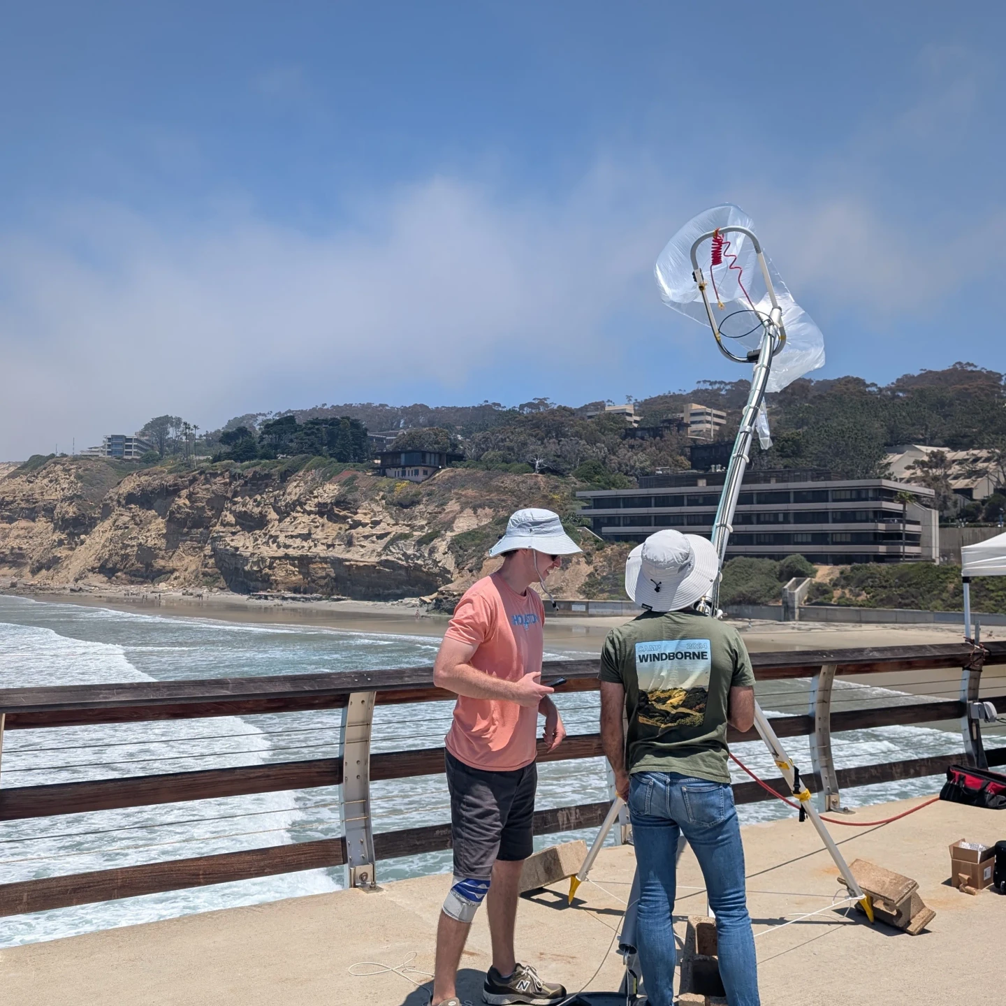 Two WindBorne employees preparing to launch a global sounding balloon on the pier.