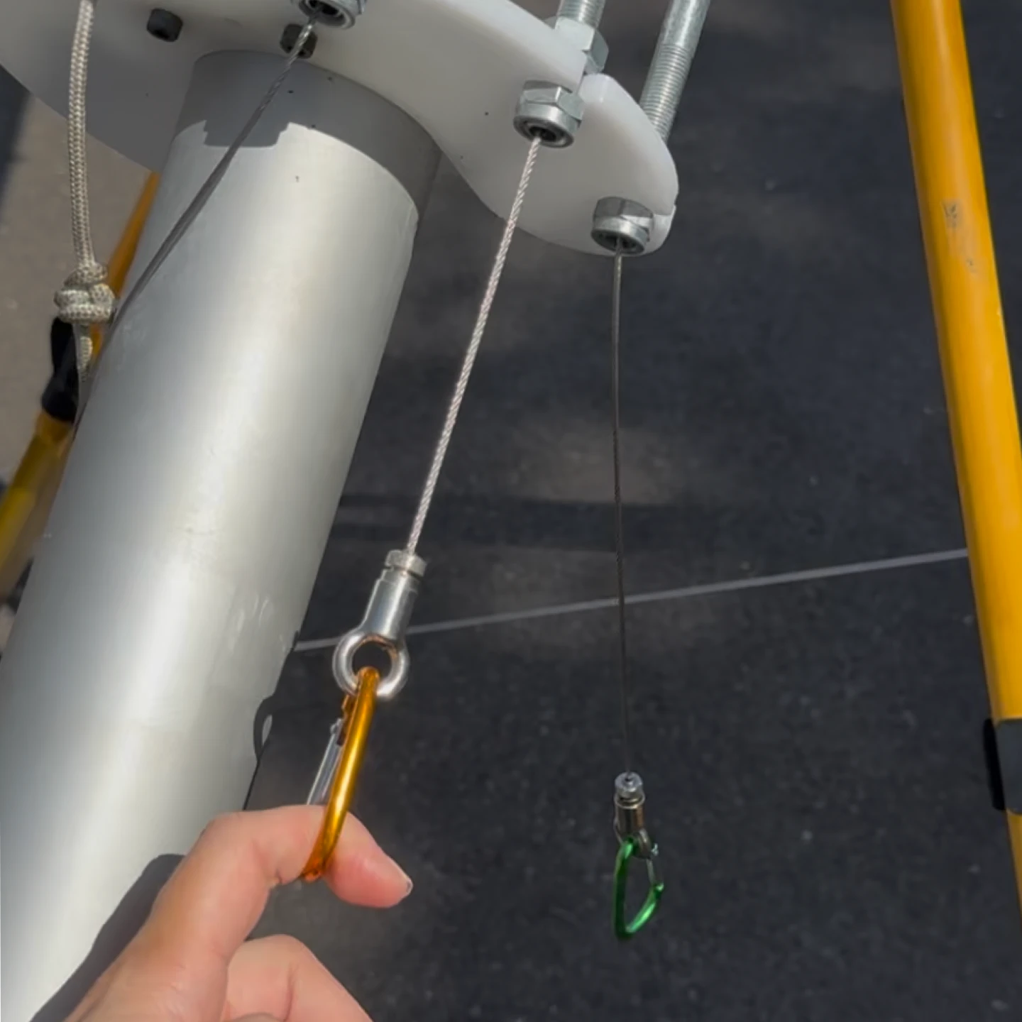 Close-up of a hand touching a carabiner on the launch rig.