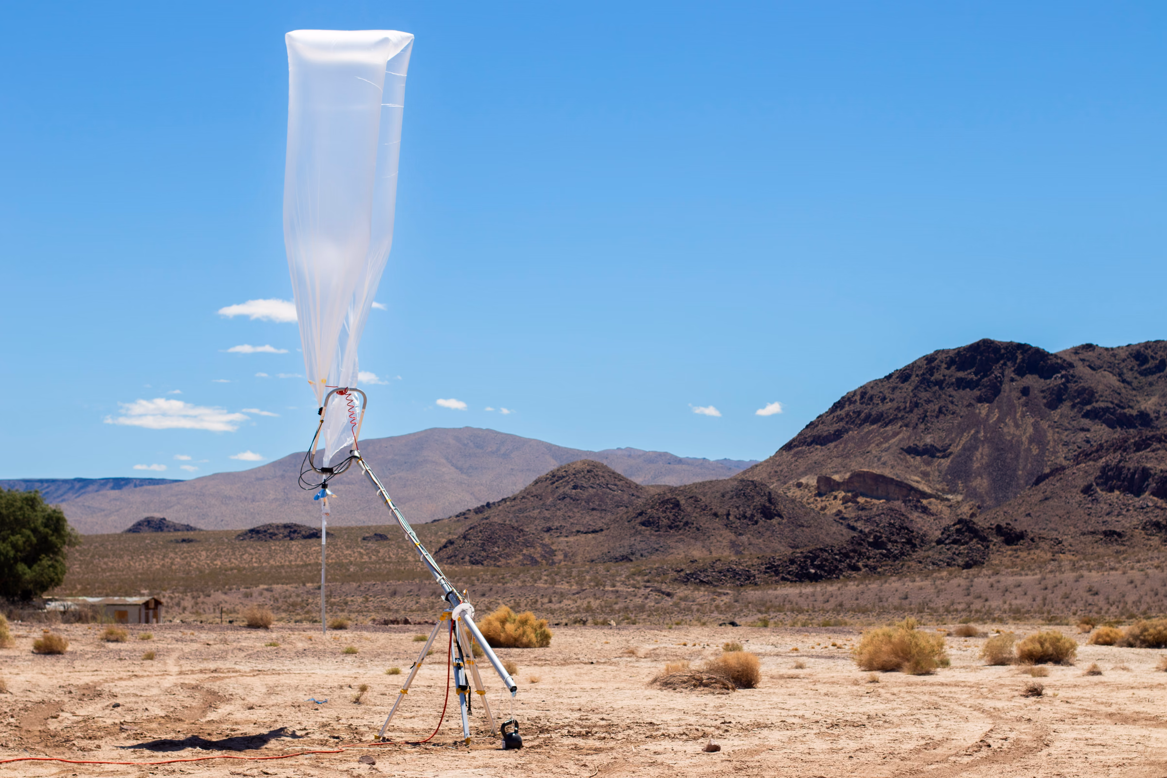 A WindBorne balloon and hardware mounted on a launch rig in a desert landscape