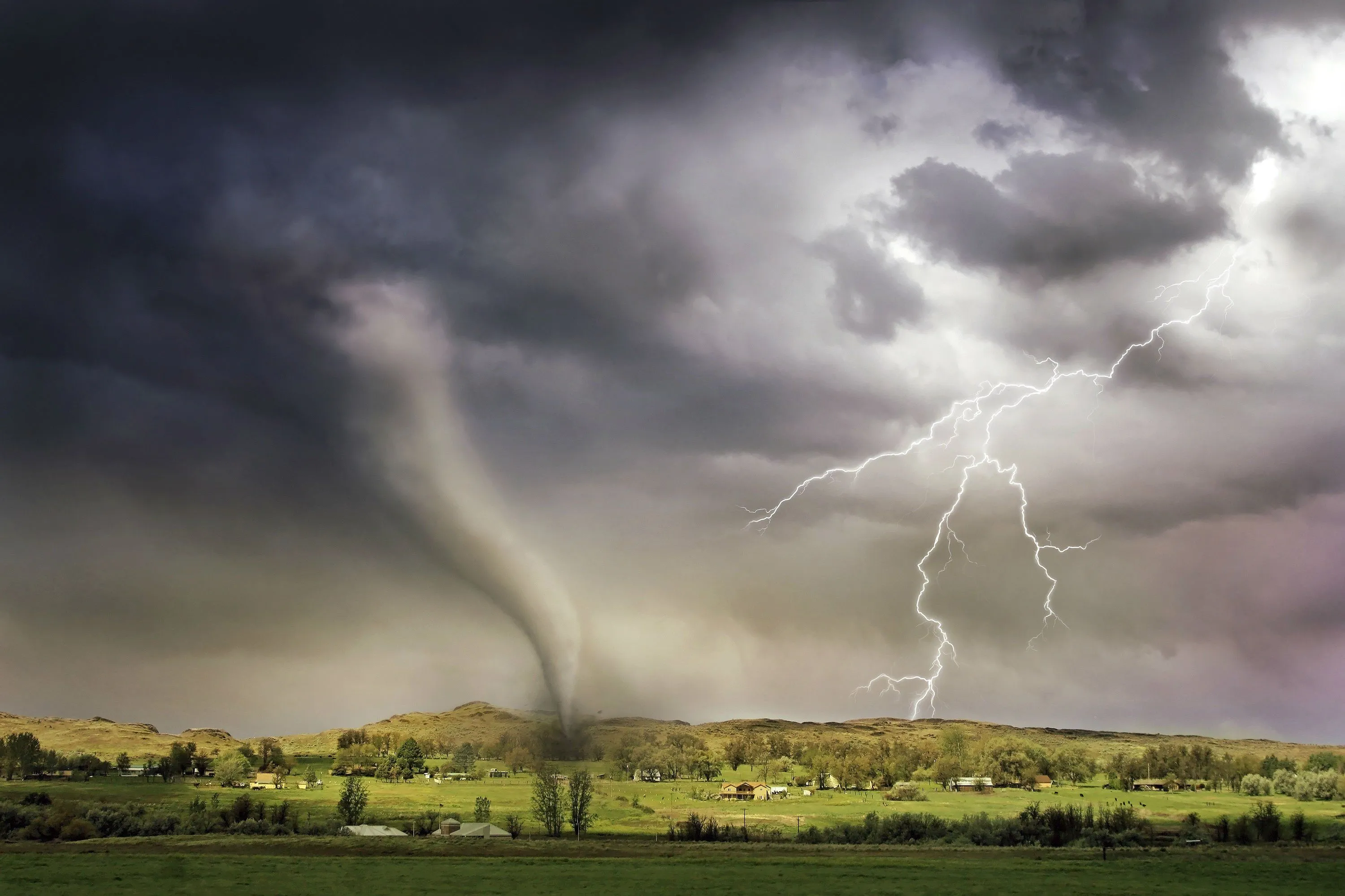 A tornado and lightning over a rural landscape